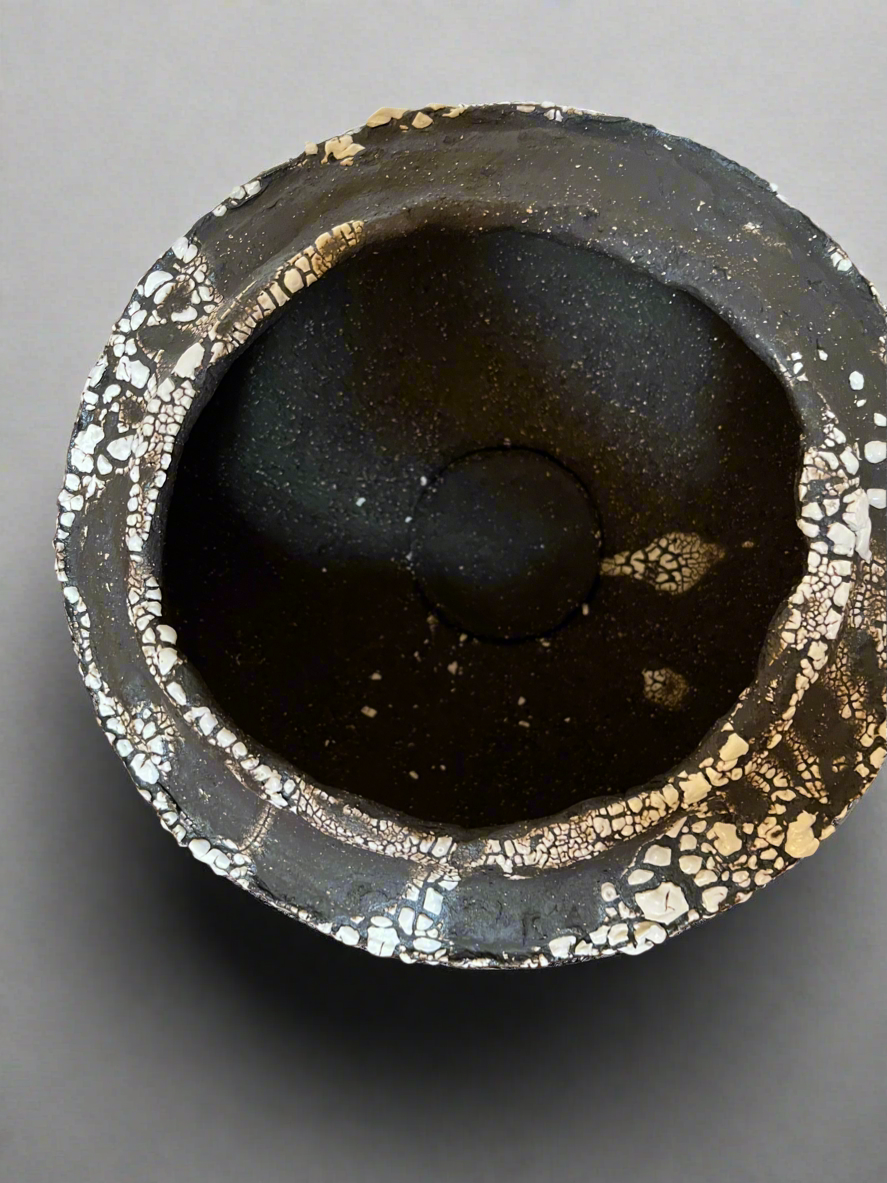 Large folded lip black stoneware bowl with white crawling glaze