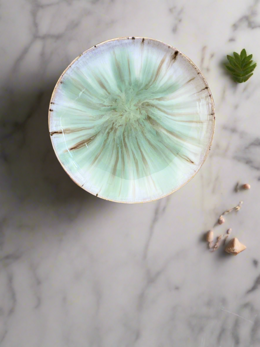 Shallow footed bowl in earthy creams and greens